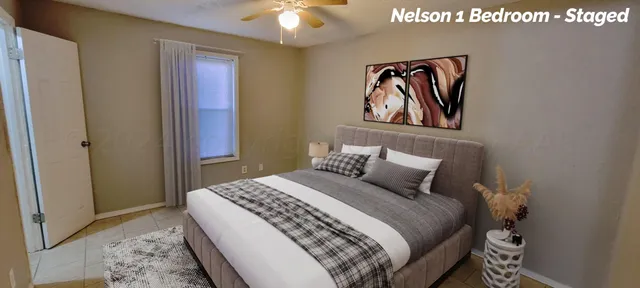 a bedroom with a bed and painting on the wall