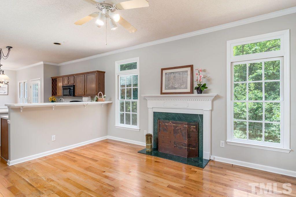 3433 Singleleaf Lane Raleigh, NC 27616 - Photo 17 of 28 a view of a livingroom with a fireplace a ceiling fan and windows