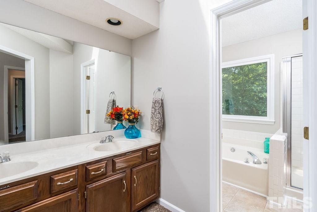 3433 Singleleaf Lane Raleigh, NC 27616 - Photo 20 of 28 a spacious bathroom with a granite countertop sink and a mirror