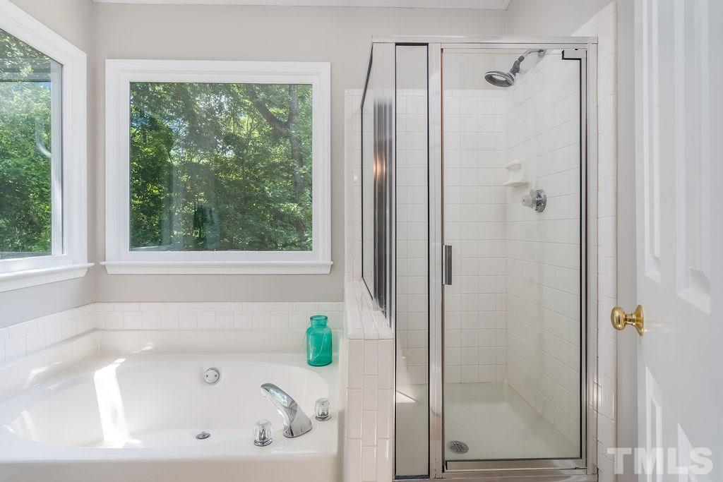 3433 Singleleaf Lane Raleigh, NC 27616 - Photo 21 of 28 a bathroom with a tub a window and a shower