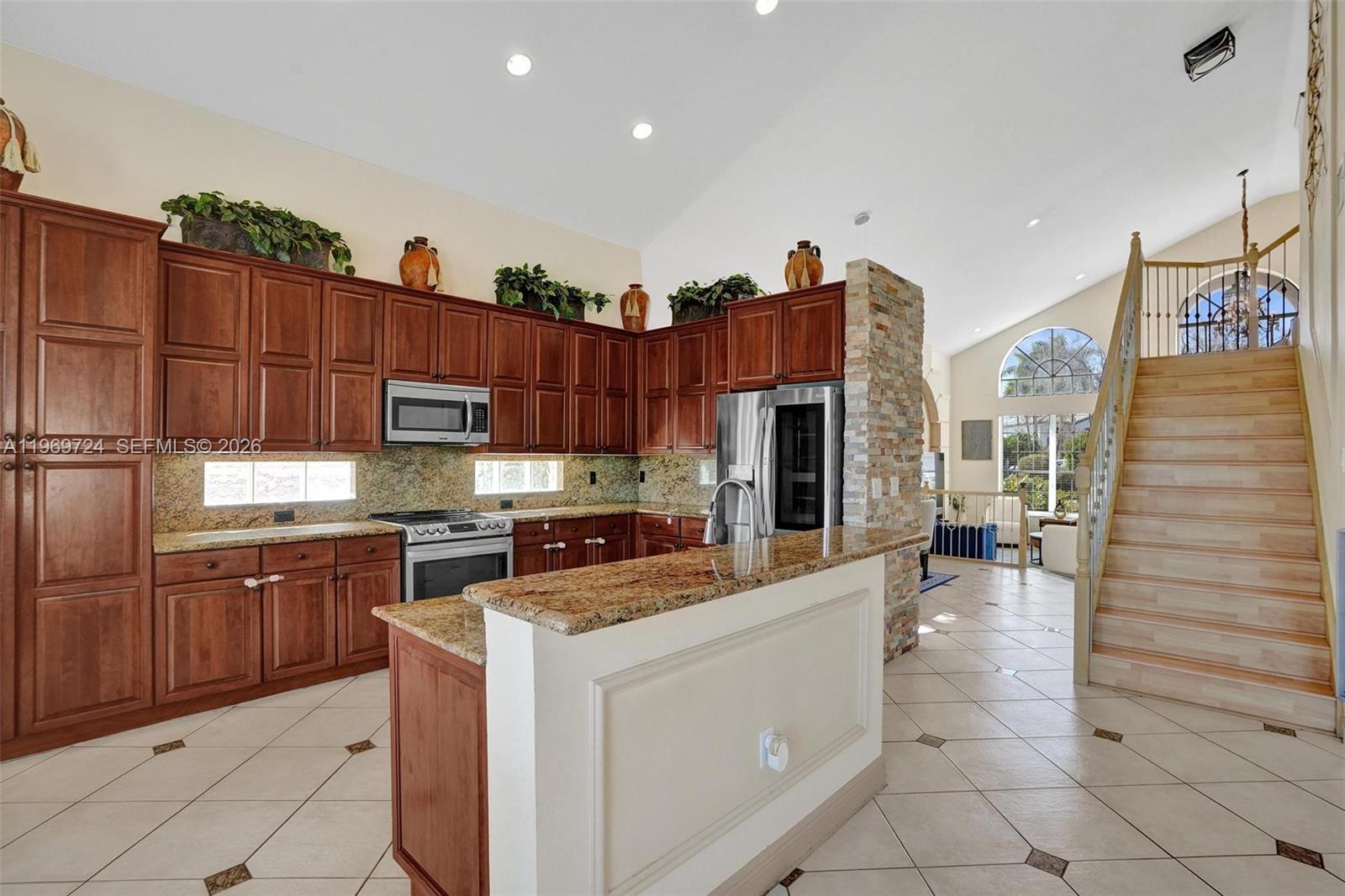 17431 Southwest 35th Street Miramar, FL 33029 - Photo 37 of 61 a kitchen with stainless steel appliances granite countertop a stove a sink dishwasher and a refrigerator with wooden cabinets