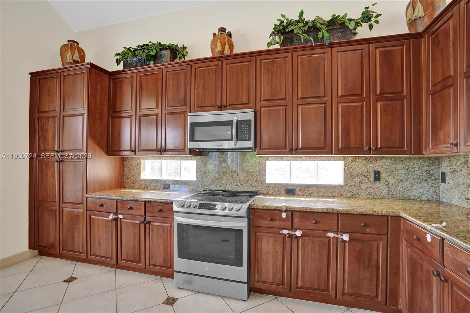 17431 Southwest 35th Street Miramar, FL 33029 - Photo 38 of 61 a kitchen with stainless steel appliances granite countertop a refrigerator and a sink