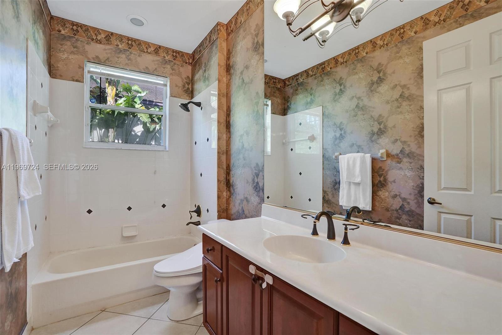 17431 Southwest 35th Street Miramar, FL 33029 - Photo 46 of 61 a bathroom with a granite countertop sink a toilet a mirror a vanity and bathtub