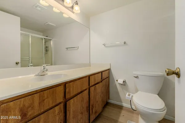 a bathroom with a granite countertop sink a toilet and a large mirror