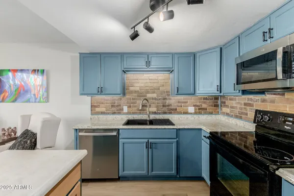 a kitchen with stainless steel appliances granite countertop a sink and stove top oven