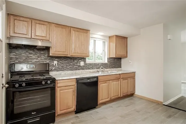 a kitchen with granite countertop a stove sink and cabinets