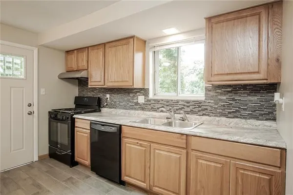 a kitchen with stainless steel appliances granite countertop a sink stove and cabinets