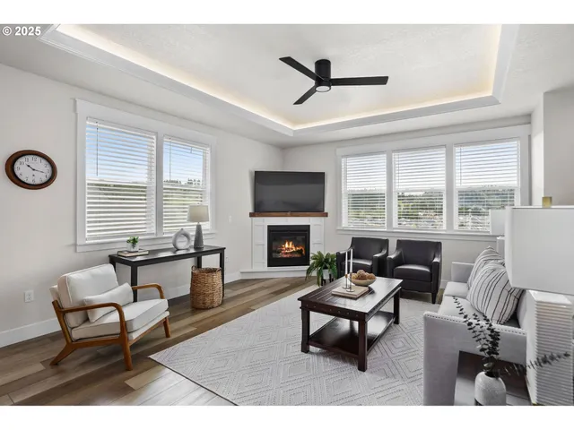 a living room with furniture a fireplace and a floor to ceiling window