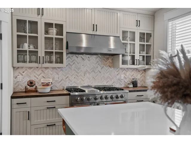 a kitchen with a stove and a white cabinets