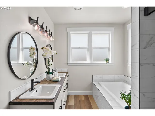 a bathroom with a tub sink and mirror