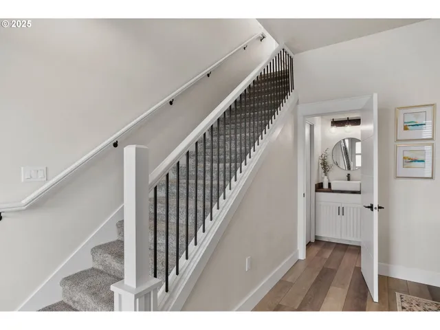a view of a hallway with wooden floor and staircase