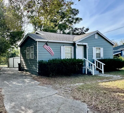 a view of a house with a yard and fence