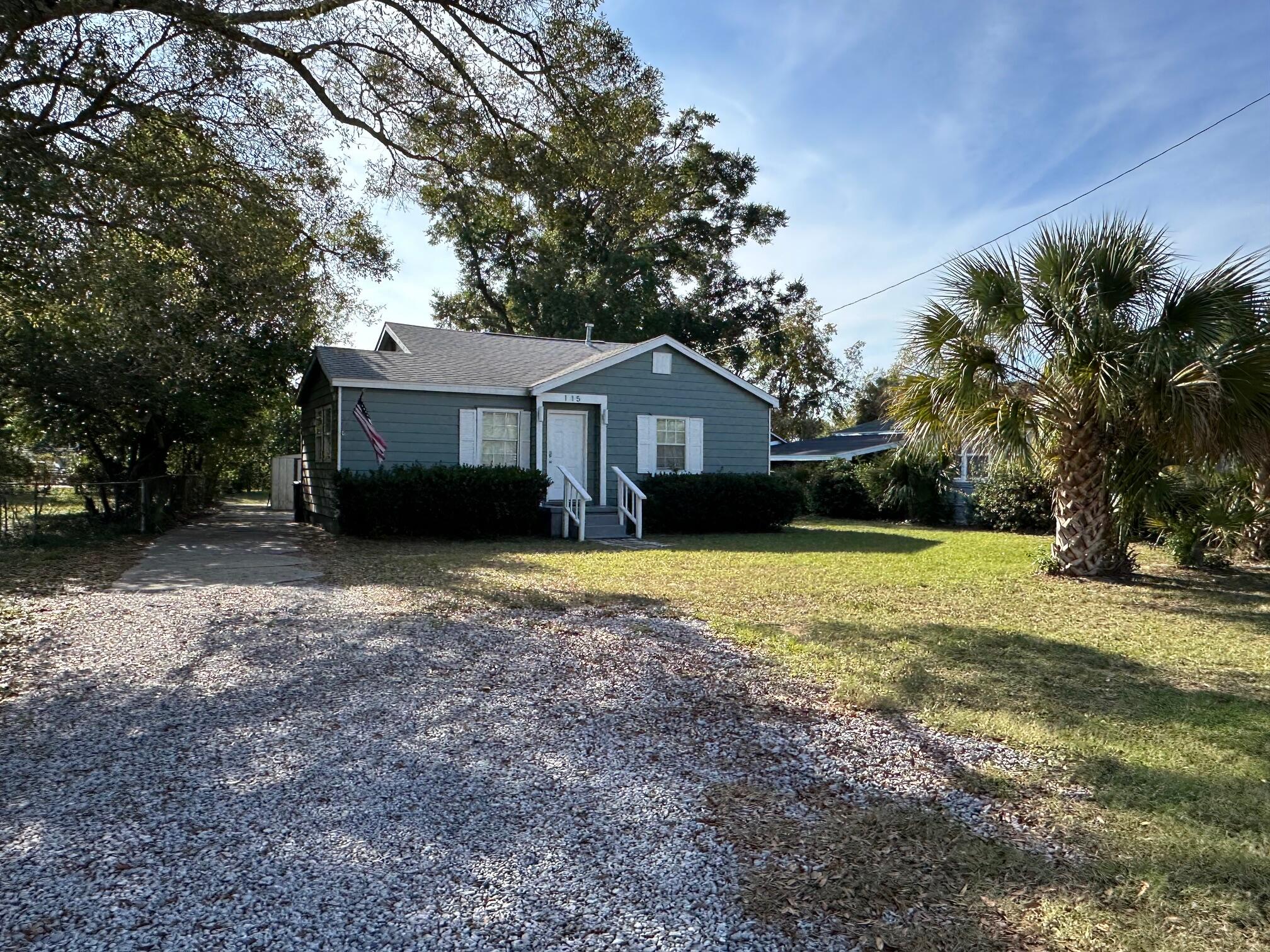 115 Milton Road Pensacola, FL 32507 - Photo 4 of 18 a front view of a house with a garden and trees