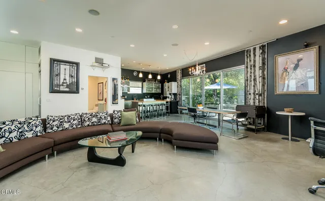 a kitchen with stainless steel appliances kitchen island granite countertop a table chairs and a refrigerator