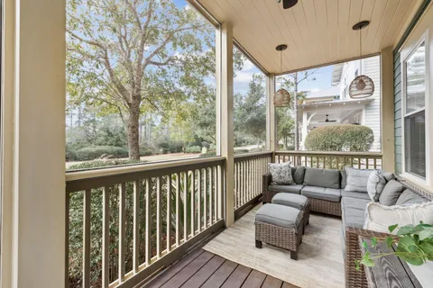 a living room with furniture a flat screen tv and a large window