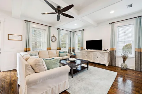 a dining room with furniture a chandelier and wooden floor