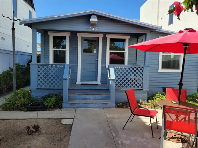 a patio with tables and chairs under an umbrella