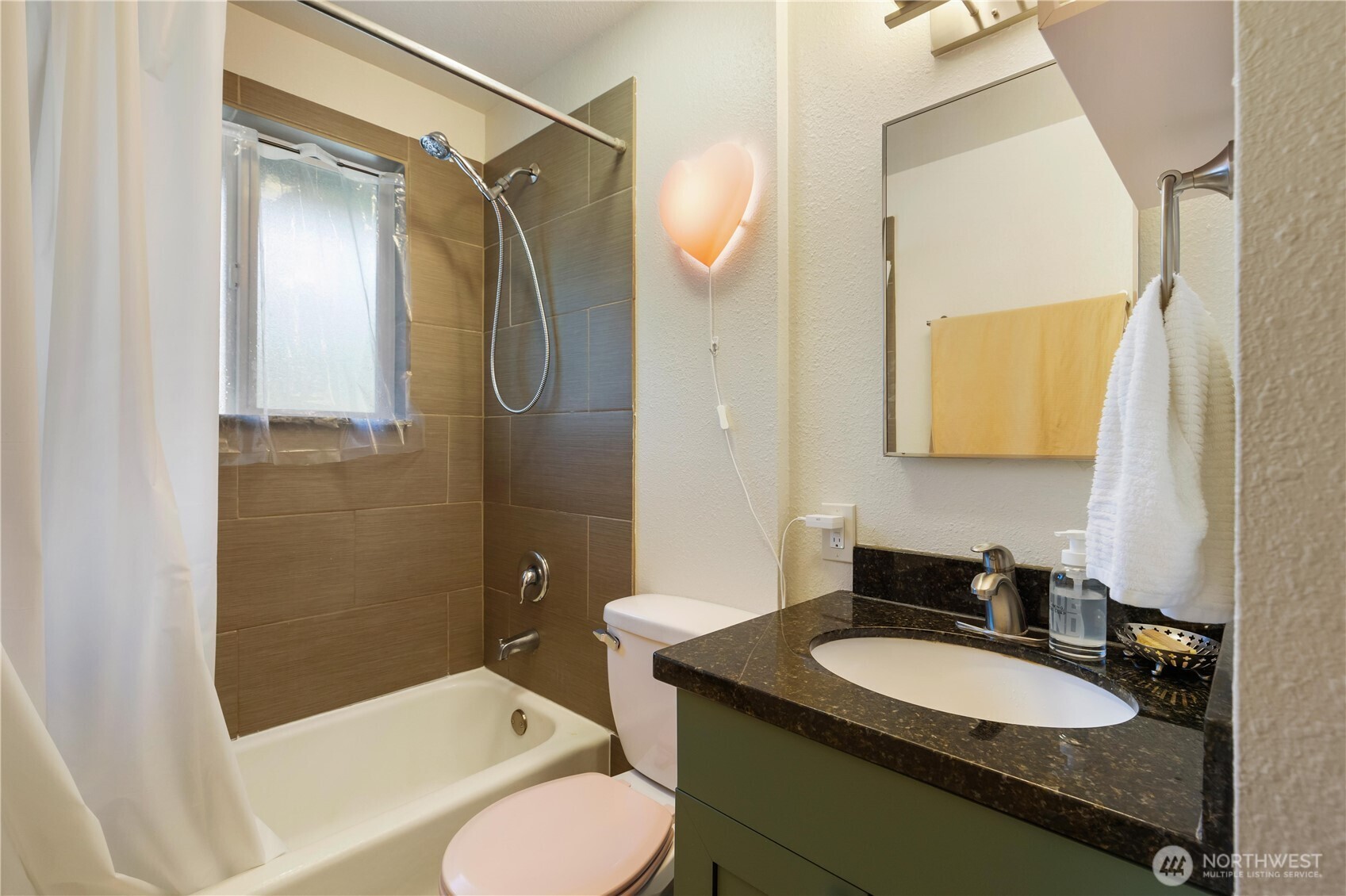 7343 35th Avenue Southwest Seattle, WA 98126 - Photo 14 of 36 a bathroom with a granite countertop sink toilet mirror and shower