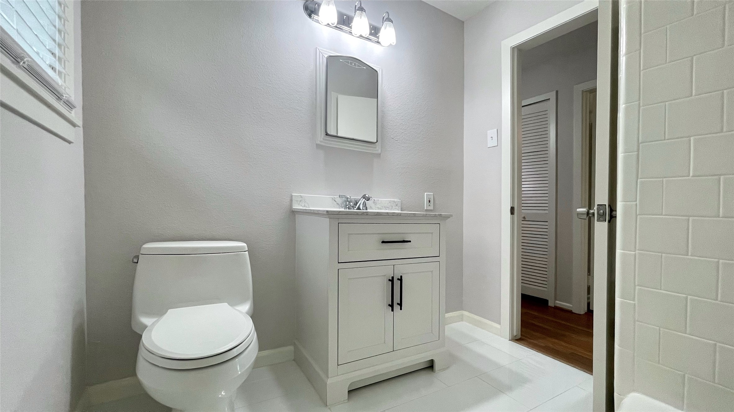 5905 Darnell Street Houston, TX 77074 - Photo 21 of 34 a bathroom with a toilet a sink a vanity and mirror