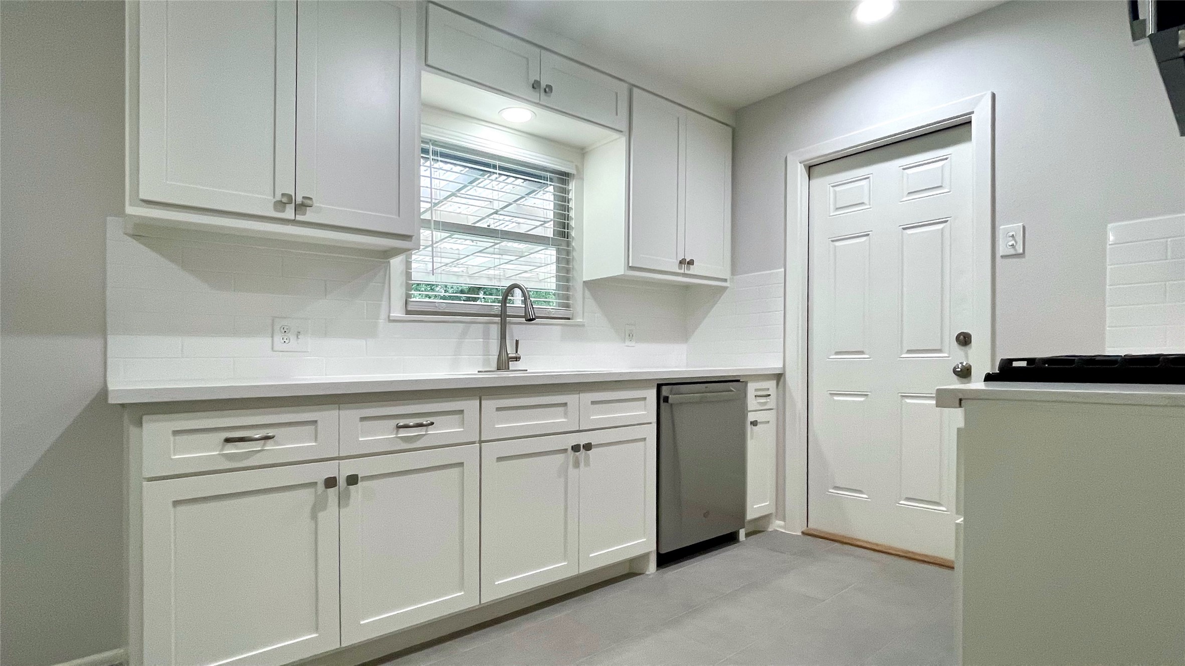 5905 Darnell Street Houston, TX 77074 - Photo 6 of 34 a kitchen with white cabinets and white appliances