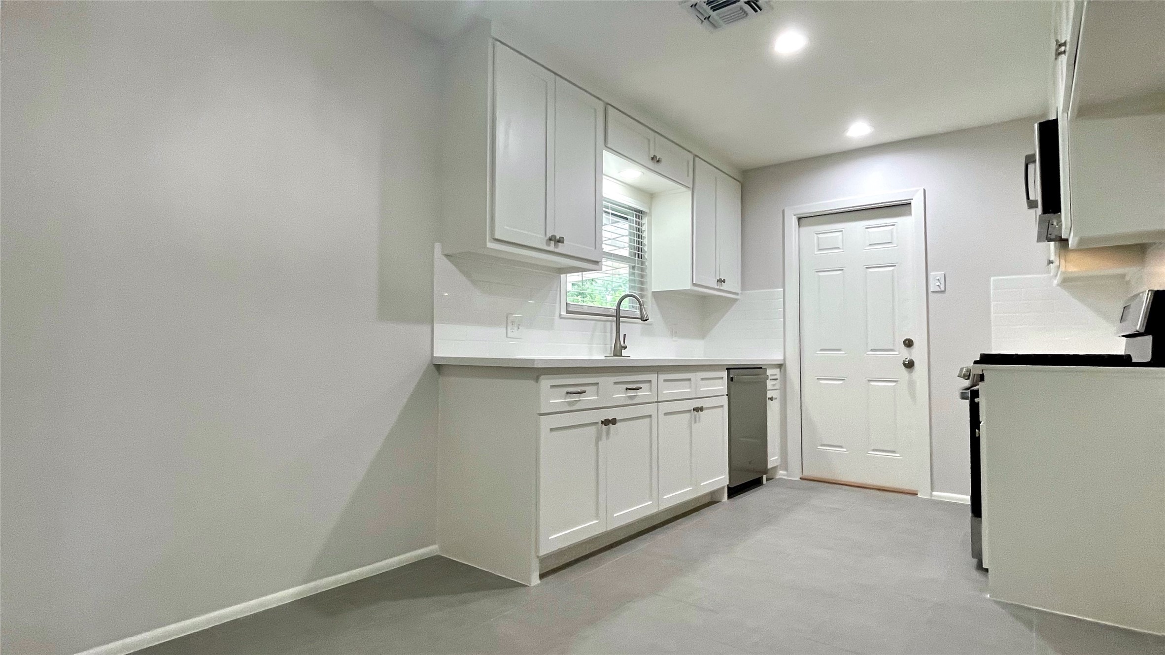 5905 Darnell Street Houston, TX 77074 - Photo 8 of 34 a kitchen with granite countertop white cabinets and white appliances