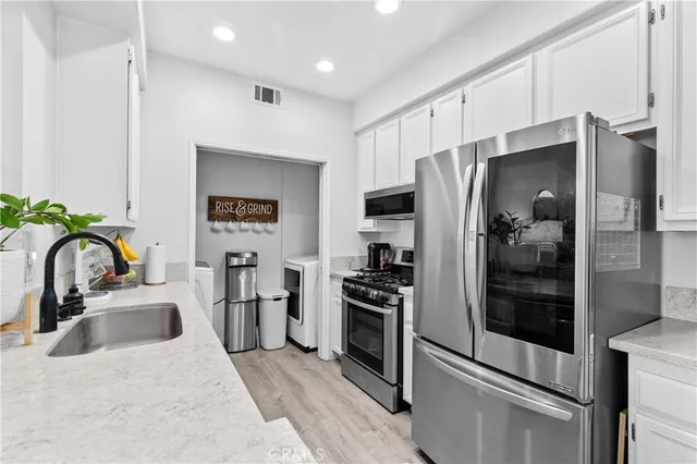 a kitchen with stainless steel appliances granite countertop a refrigerator and a sink