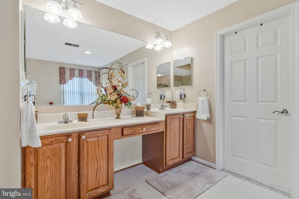 a spacious en suite bathroom with a double vanity sink and a mirror