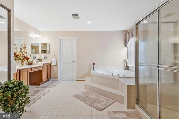 a bathroom with a tub sink shower and mirror