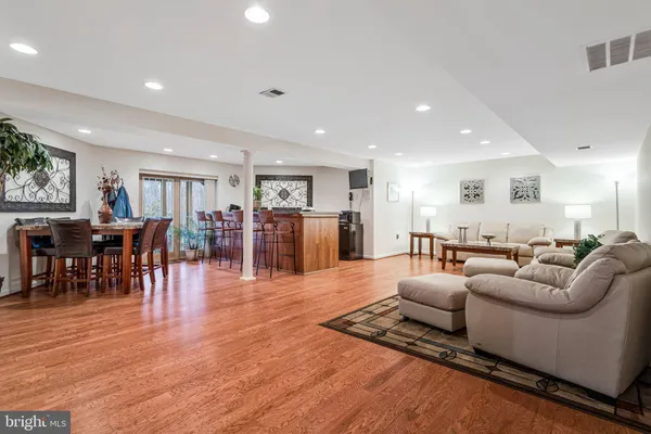 a living room with furniture wooden floor and kitchen view
