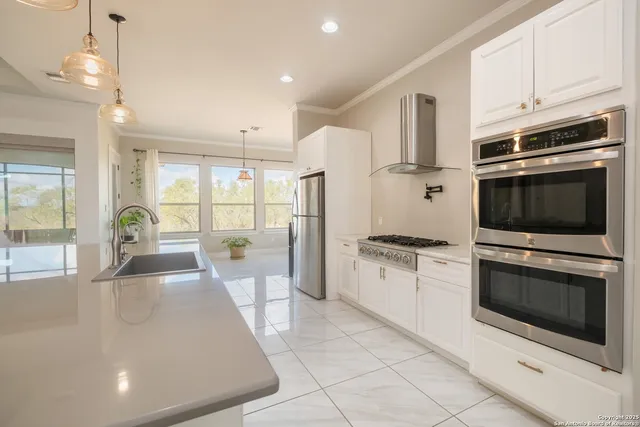a kitchen with stainless steel appliances granite countertop a stove a sink and a refrigerator