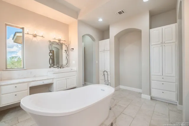 a bathroom with a tub a sink and mirrors