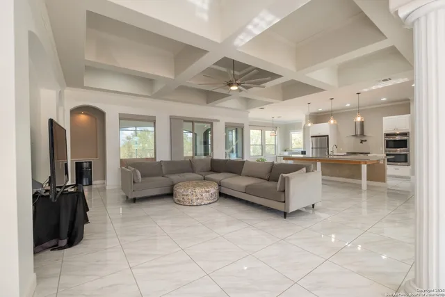a living room with furniture and a view of kitchen