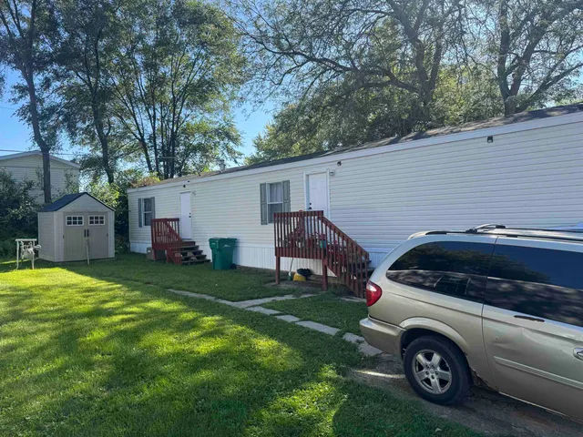 a view of a car parked in front of a house with a yard
