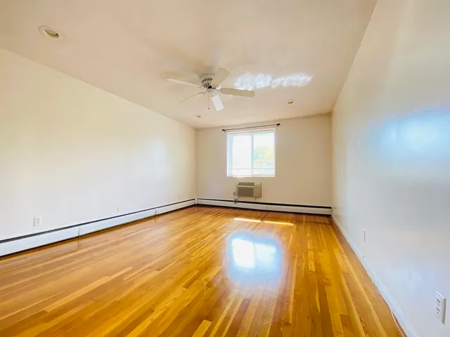 a view of a room with wooden floor and fan