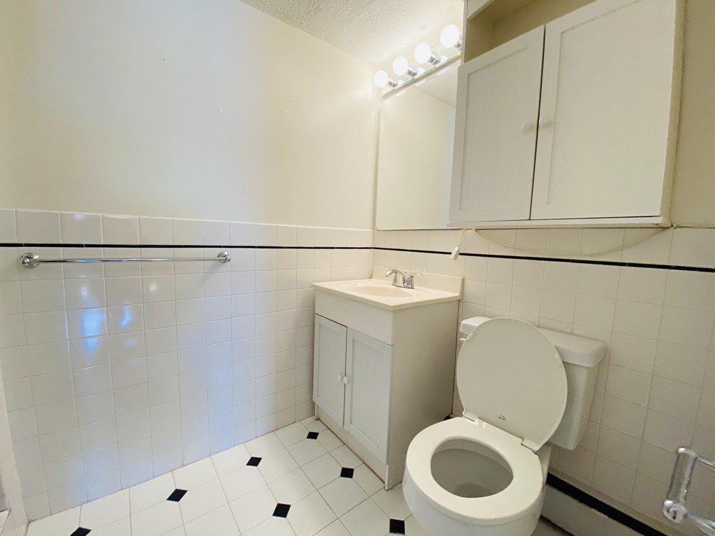 50 Green Street, Unit 209 Brookline, MA 02446 - Photo 7 of 16 a white toilet sitting next to a bathroom sink
