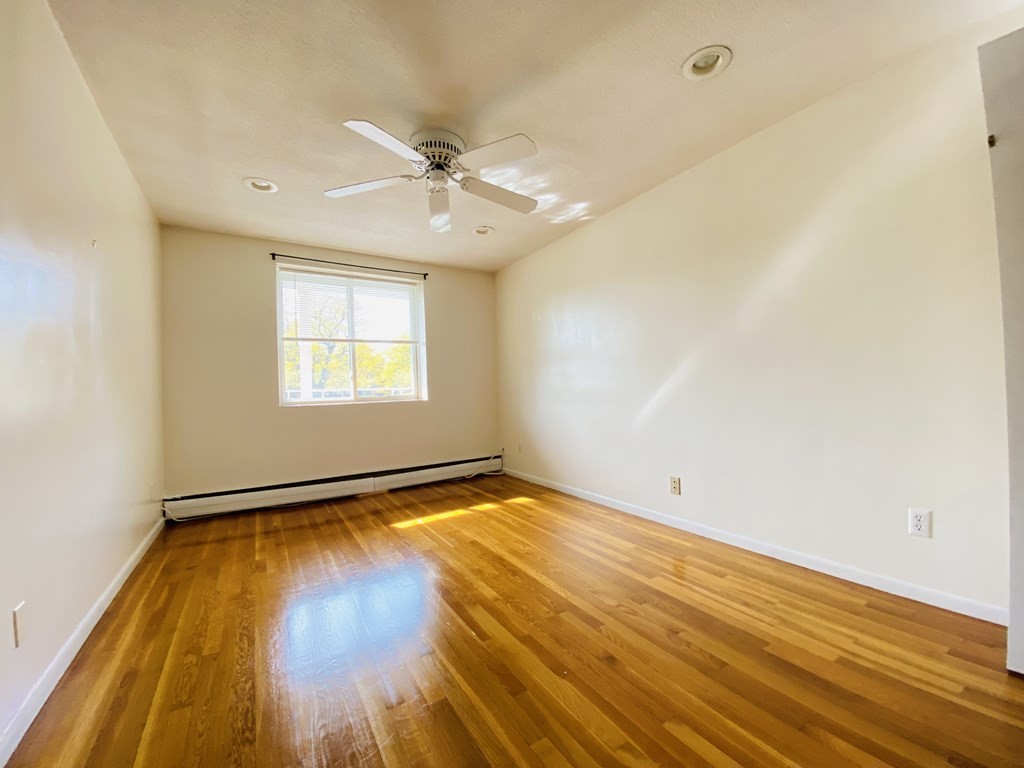 50 Green Street, Unit 209 Brookline, MA 02446 - Photo 8 of 16 an empty room with wooden floor fan and windows