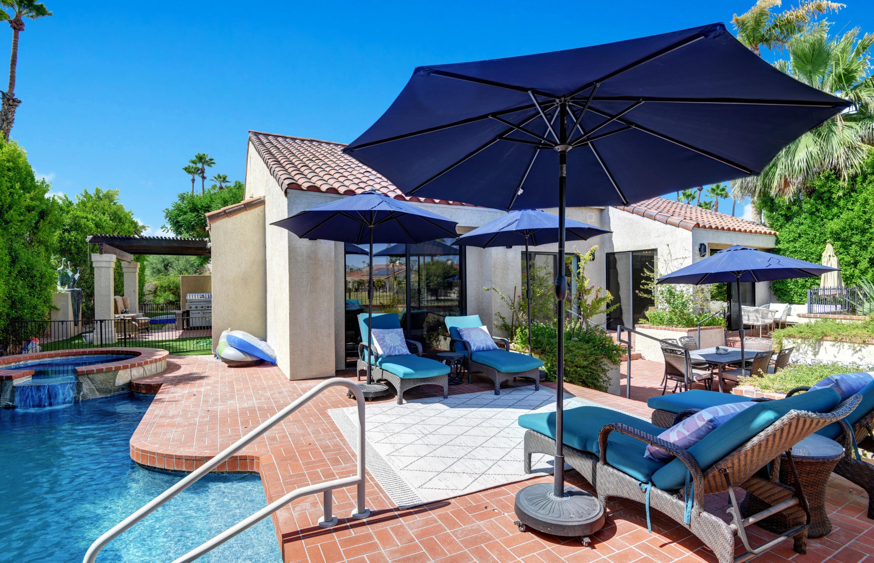 a view of patio with chairs and table under an umbrella