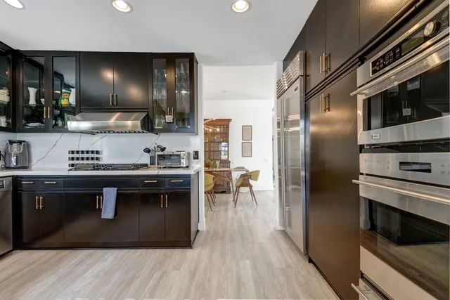 a kitchen with stainless steel appliances granite countertop a stove a sink and a refrigerator