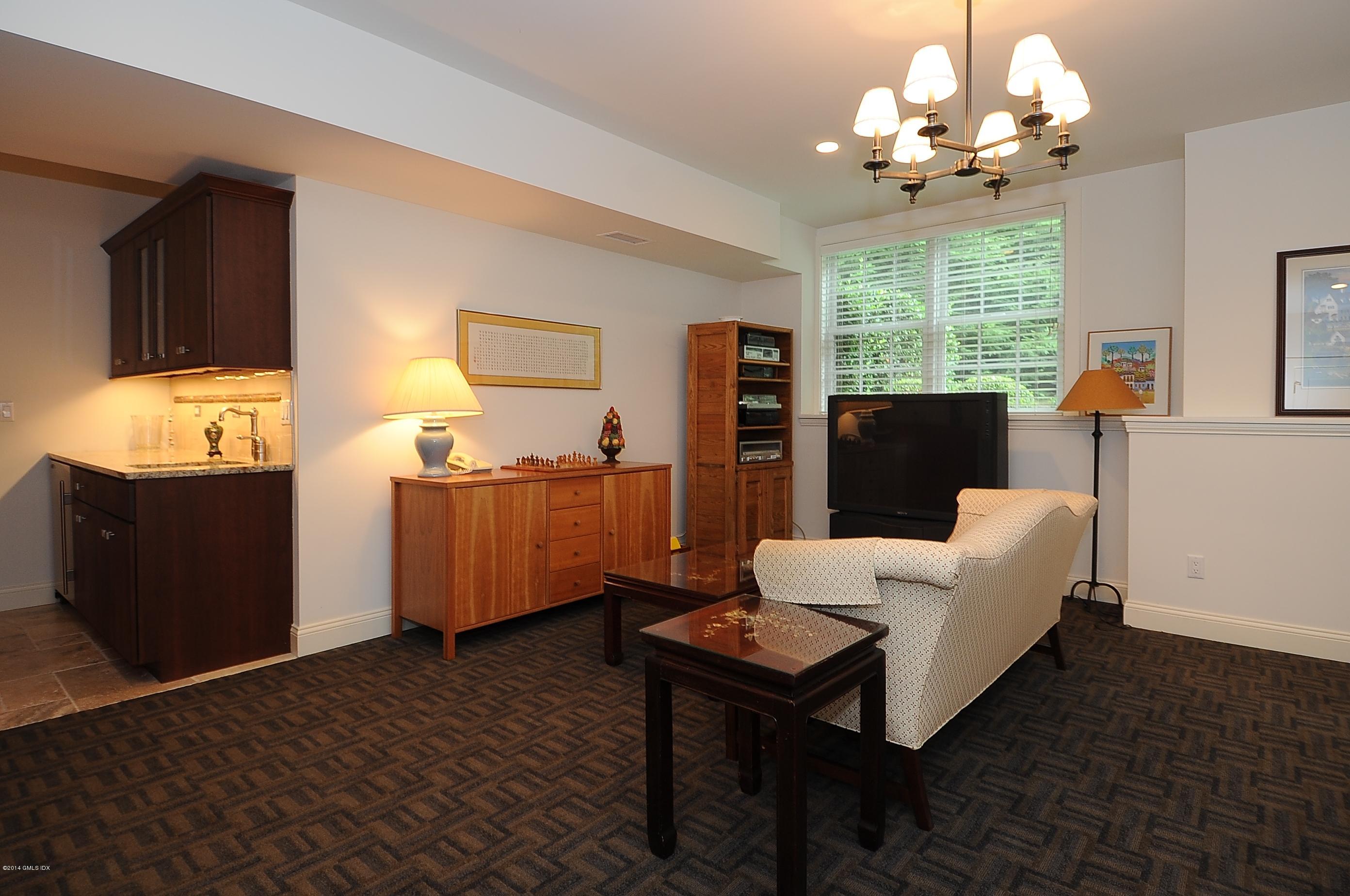 340 Valley Road, Unit 3 Cos Cob, CT 06807 - Photo 43 of 53 a living room with furniture a large window and a chandelier