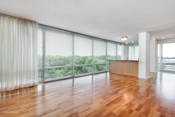 a view of a kitchen with wooden floor and windows