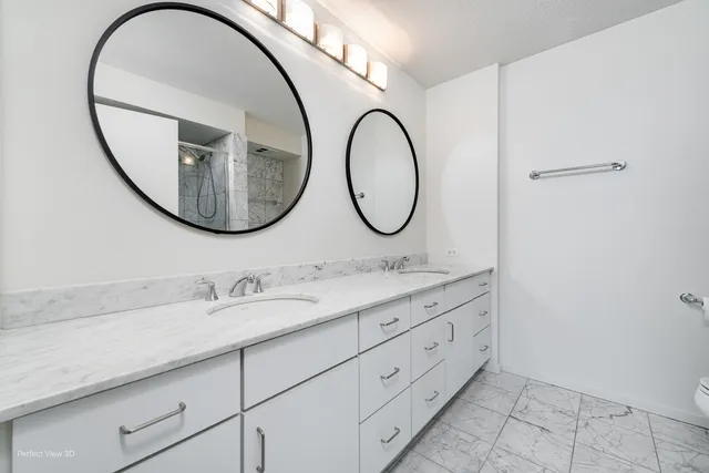a bathroom with a granite countertop double vanity sink and a mirror