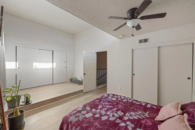 a bedroom with a bed and a large mirror with a chandelier
