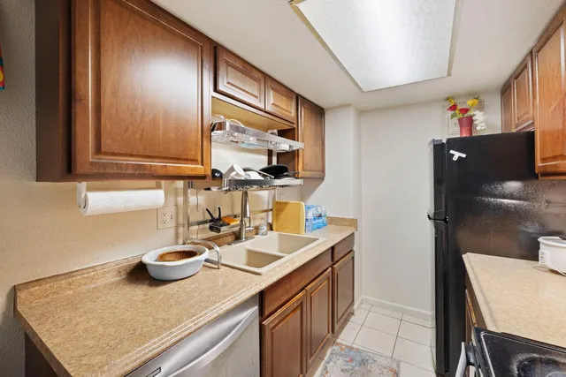 a kitchen with a sink refrigerator and cabinets