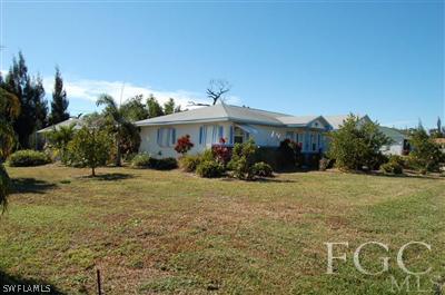 5871 Tarpon Road Bokeelia, FL 33922 - Photo 1 of 8 a front view of a house with garden
