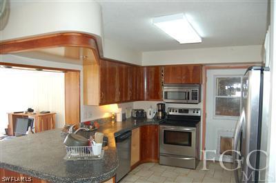 5871 Tarpon Road Bokeelia, FL 33922 - Photo 4 of 8 a kitchen with a stove and a refrigerator