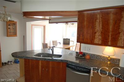5871 Tarpon Road Bokeelia, FL 33922 - Photo 5 of 8 a kitchen with a granite countertop sink stove and cabinets