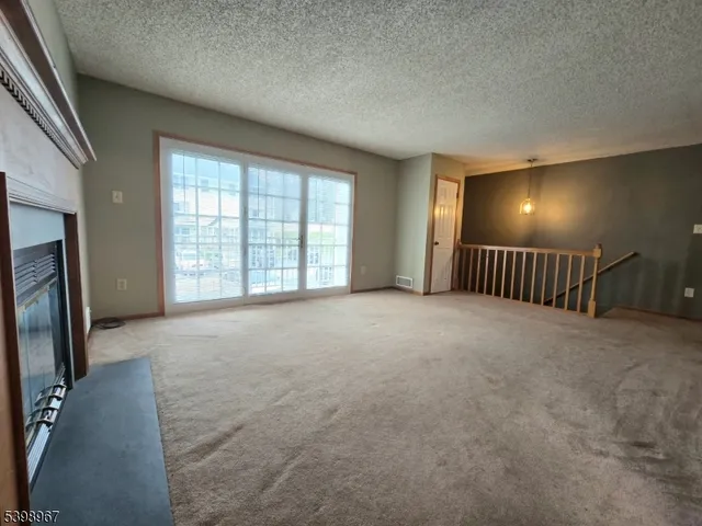 a view of an empty room with glass door and windows