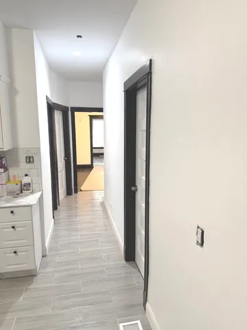 a view of a hallway with wooden floor and cabinet