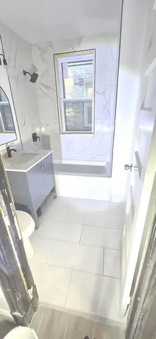 a bathroom with a tub sink and mirror