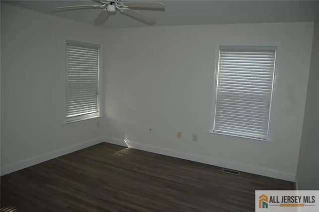 an empty room with wooden floor and a window